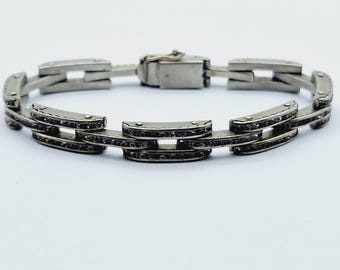 May include: A silver bracelet with a chain link design. Each link is set with small, clear stones.