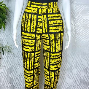 May include: Black and yellow high-waisted pants with a geometric pattern. The pants are made of a lightweight fabric and have a relaxed fit.