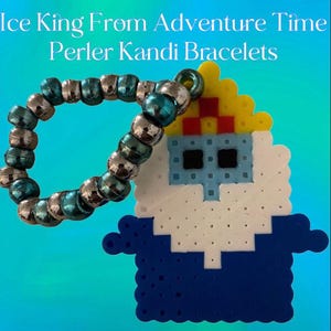 Könnte beinhalten: Ein blauer, weißer, gelber und roter Perlenarmband-Anhänger von Ice King aus Adventure Time. Der Anhänger ist an einem türkisfarbenen und silbernen Kandi-Armband befestigt.