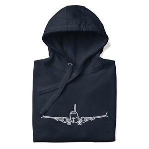 Puede incluir: Una sudadera con capucha azul marino con un avión blanco en contorno en la parte delantera.