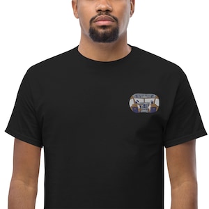 Puede incluir: Una camiseta negra con una pequeña imagen bordada de una cabina de avión.