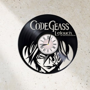 May include: Black vinyl record clock featuring a character from the anime Code Geass: Lelouch of the Rebellion. The clock face is white with black Roman numeral markings and a pink background.