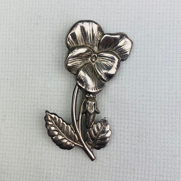 Pansy pin with stem and two leaves in a light weight silver-tone metal.