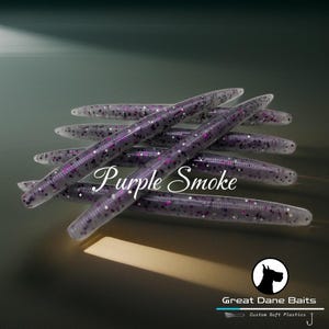 May include: Purple Smoke scented fishing lures with glitter. The lures are long and thin, with a pointed end. The packaging includes the text "Great Dane Baits Custom Soft Plastics".