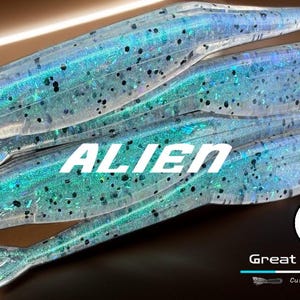 May include: Three translucent blue fishing lures with the word "ALIEN" in white text. The lures have a speckled design and a tail-like structure. The Great Dane Baits logo is in the bottom right corner.