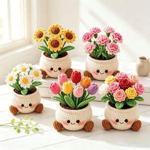May include: Five crocheted potted plants featuring smiling cream-coloured pots with brown feet and pink cheeks. The plants include yellow sunflowers, pink carnations, white daisies, multicoloured tulips, and a mix of pink, yellow, and red roses.