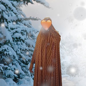 May include: A person wearing a long, brown, patterned robe with a heart-shaped object covering their face. The person is standing in a snowy landscape.