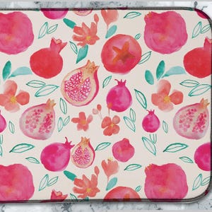 May include: A pink and white dish drying mat with a watercolour pattern of pomegranates and flowers.