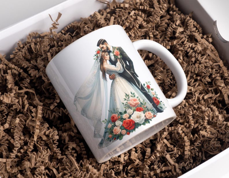 May include: White ceramic mug with a colorful illustration of a bride and groom embracing, surrounded by red, white, and pink flowers.