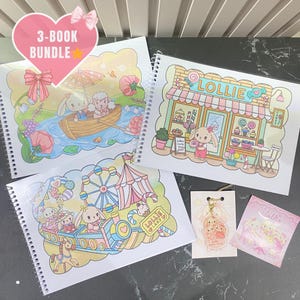 Op de afbeelding: Een set van 3 spiraalgebonden kleurboeken met pastelkleurige illustraties van konijnen in een boot, een snoepwinkel met het opschrift LOLLIE en een kermis genaamd LOLLIE LAND. Inclusief een kleine konijnenhanger en een vierkante sticker.