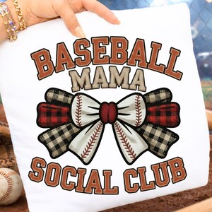 May include: White square pillow with the text "BASEBALL MAMA SOCIAL CLUB" in brown and tan lettering. A baseball-themed bow with red and black plaid accents is in the center. A baseball is visible in the background.