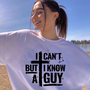 May include: White sweatshirt with a black graphic that says "I can't but I know a guy" with a cross in the middle.