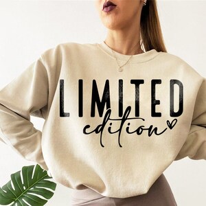 May include: A beige sweatshirt with the text "LIMITED edition" printed in black with a small heart symbol.