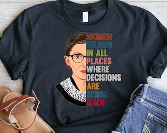 May include: Black t-shirt with a portrait of Ruth Bader Ginsburg and the text "Women Belong In All Places Where Decisions Are Being Made".