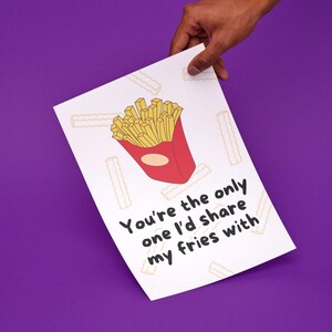 Puede incluir: Una tarjeta blanca con una ilustración de dibujos animados de papas fritas en rojo y amarillo. El texto en la tarjeta dice "Eres la única con la que compartiría mis papas fritas."