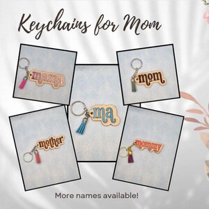 May include: Five wooden keychains with different names for mom, including "mama", "mom", "ma", "mother", and "mommy". Each keychain has a small tassel attached.