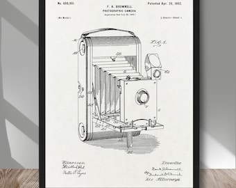 May include: A black and white line drawing of a photographic camera patent, No. 698,901, patented 29th April 1902, by F.A. Brownell. The drawing shows a detailed view of the camera's design, including the bellows, lens, and other components.
