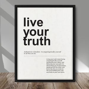 May include: A framed print with the words "live your truth" in bold black letters. Below, smaller text defines authenticity and the meaning of living truthfully. The print is in a black frame, set against a light background.