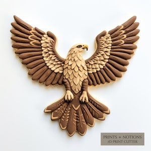 May include: A brown and tan detailed cookie cutter in the shape of an eagle with its wings spread. The cookie cutter is made for making cookies or fondant decorations. The text "PRINTS + NOTIONS 3D PRINT CUTTER" is at the bottom of the image.