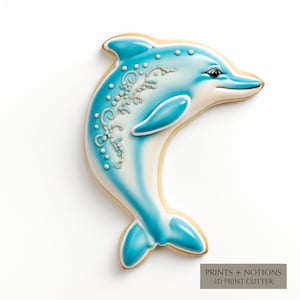 May include: A blue and white dolphin cookie cutter, with a decorative design, for making cookies.  PRINTS + NOTIONS 3D PRINT CUTTER.