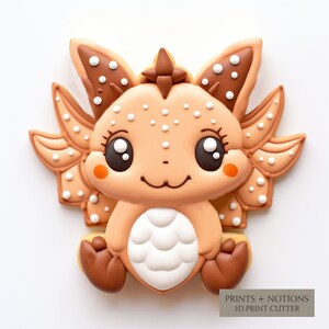 May include: A brown and white cookie decorated with a cute cartoon dragon design. The dragon has large eyes, a small mouth, and a white belly with scales. The cookie is decorated with white dots and brown accents.