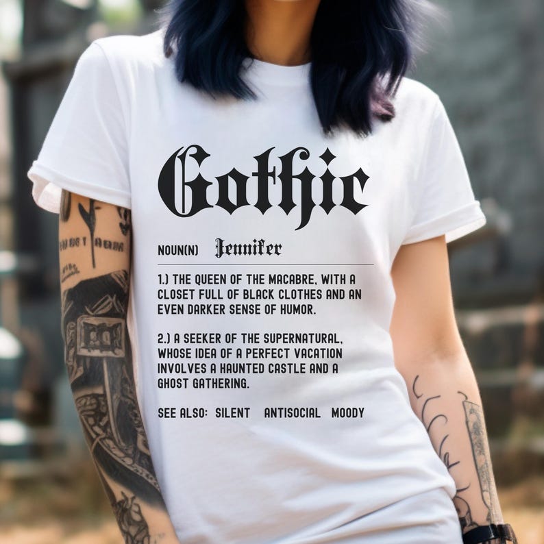 Puede incluir: Camiseta blanca con texto negro que dice "Gothic" en una fuente g&oacute;tica. El texto se define como "La reina de lo macabro, con un armario lleno de ropa negra y un sentido del humor a&uacute;n m&aacute;s oscuro. Un buscador de lo sobrenatural, cuya idea de unas vacaciones perfectas implica un castillo encantado y una reuni&oacute;n de fantasmas. Ver tambi&eacute;n: Silencioso, Antisocial, Melanc&oacute;lico."