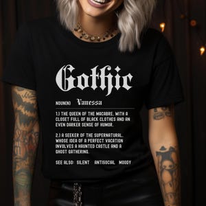 Puede incluir: Camiseta negra con texto blanco que dice "Gothic" y una definici&oacute;n de la palabra. La definici&oacute;n incluye el nombre "Vanessa" y las frases "Reina de lo macabro", "armario lleno de ropa negra", "sentido del humor m&aacute;s oscuro", "buscador de lo sobrenatural", "castillo encantado" y "reuni&oacute;n de fantasmas".