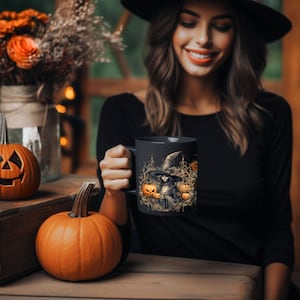 May include: Black coffee mug with a Halloween-themed design featuring a witch with a pointed hat and pumpkins. The witch is surrounded by a dark forest setting.