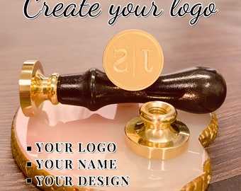 May include: Gold-toned wax seal stamp with a wooden handle. The stamp features the initials "2J" in a decorative font. The text "Create your logo" is visible at the top of the image. Below the stamp, the text "YOUR LOGO", "YOUR NAME", and "YOUR DESIGN" is displayed.