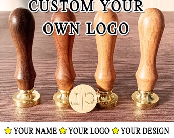 Peut inclure: Quatre poignées de tampons en bois avec des bases en métal doré et un tampon rond gravé avec les lettres "J|C" sur une surface en bois. Le texte "CUSTOM YOUR OWN LOGO" est au-dessus des tampons. Le texte "YOUR NAME", "YOUR LOGO" et "YOUR DESIGN" sont en dessous des tampons.