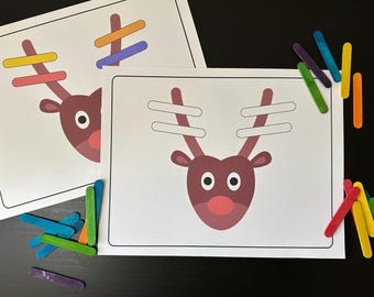 May include: A printable reindeer craft activity with a brown reindeer head and white antlers. The antlers are missing and need to be filled in with craft sticks. The craft sticks are in various colors, including red, orange, yellow, green, blue, and purple.
