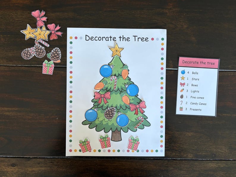 May include: A Christmas-themed activity set with a decorated tree illustration and the text "Decorate the Tree." Includes cutouts of ornaments, bows, stars, pine cones, and presents. A list of items is also included.