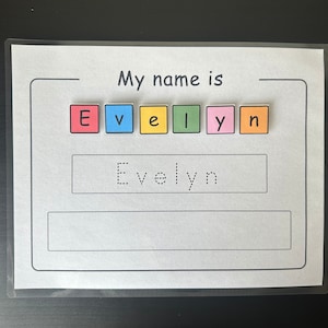 May include: A white name tracing worksheet with the words "My name is" at the top. The name "Evelyn" is spelled out with colorful letter blocks above the dotted line for tracing the name. Below the dotted line is the name "Evelyn" in dotted letters.