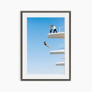 a man standing on the edge of a building while another man flies a kite