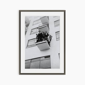 a black and white photo of people on a balcony