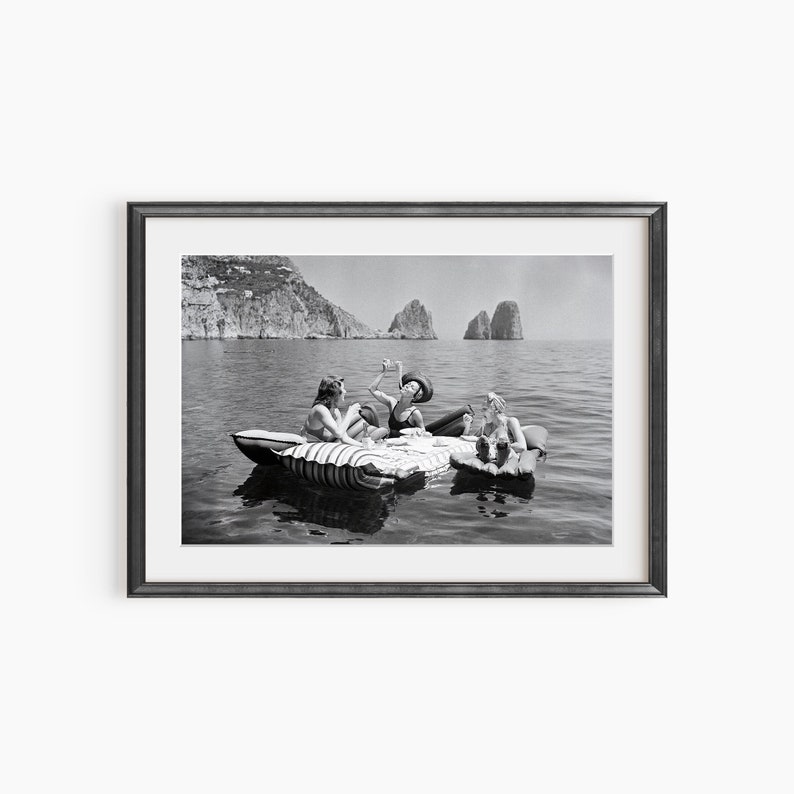 a black and white photo of three people in a boat