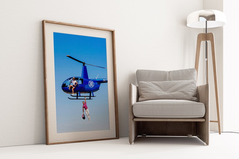 a picture of a helicopter hanging on a wall next to a chair