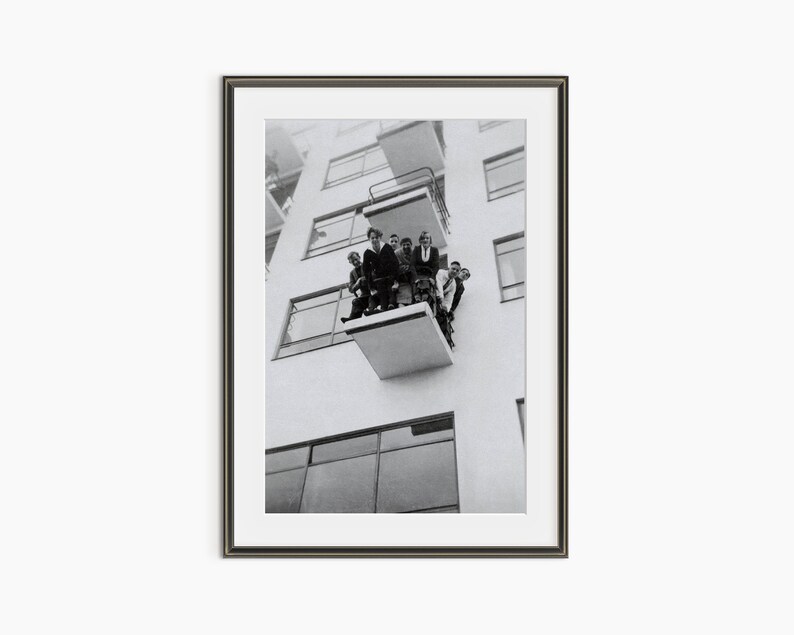 a black and white photo of people on a balcony