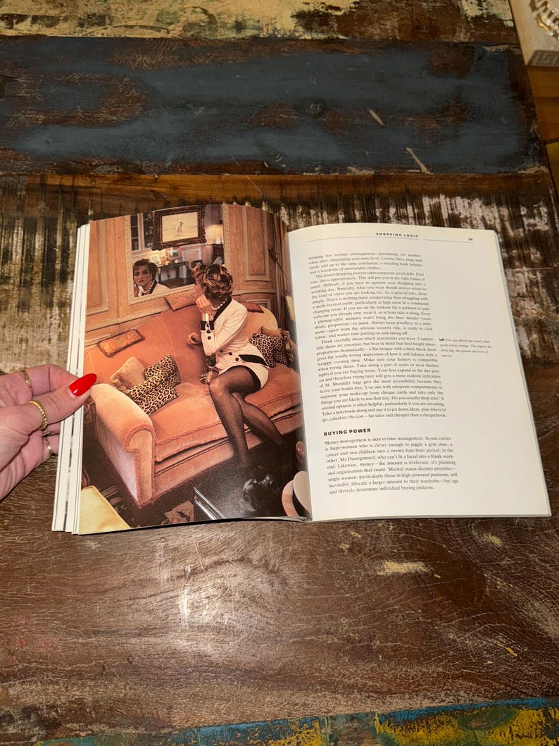 May include: A woman in a white and black dress sits on a pink velvet sofa with leopard print pillows. The sofa is in a room with a mirror reflecting a man in a white shirt. The text on the page reads "Shopping Logic" and "Buying Power".