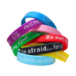 Puede incluir: Un conjunto de pulseras de silicona de colores con mensajes inspiradores, que incluyen "And the", "1 Cor. 15:26", "Doing Good", "Isaiah 30:15", "Your strength", "Do not be", "be afraid... for I am", "Nothing" y "wing, death, is to be".