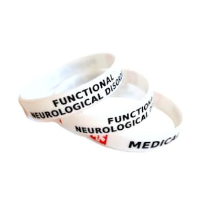 Könnte beinhalten: Drei weiße Silikon-Armbänder mit dem Text "FUNCTIONAL NEUROLOGICAL DISORDER" und "MEDICAL" in schwarzer Schrift.