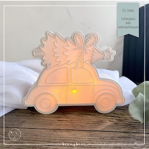 Puede incluir: Decoración luminosa en forma de coche color melocotón con un árbol de Navidad blanco encima. La decoración tiene el texto "STL-Datei: Lichterglanz Auto Weihnachtsbaum". El coche emite un brillo naranja cálido.