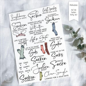 Peut inclure: Une feuille de papier blanche avec diverses phrases et illustrations sur le thème des chaussettes en écriture noire. Les phrases incluent "chaussettes perdues", "à la recherche d'âmes sœurs" et "la vie est meilleure avec des pieds chauds".