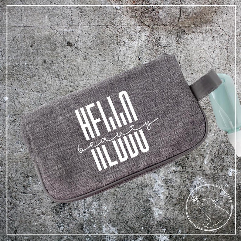May include: Gray zippered pouch with a white graphic that says "HELLO beauty WORLD".