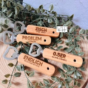 May include: Four wooden bottle openers with different engraved sayings. The sayings are "Zisch und Weg", "Problem L&ouml;ser", "0.5er Schl&uuml;ssel", and "Endlich Wochenende".