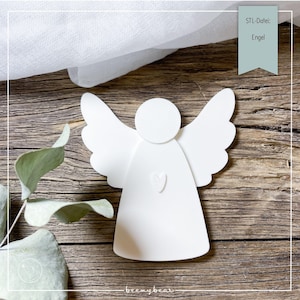 Può includere: Decorazione bianca a forma di angelo, con ali spiegate e un dettaglio a forma di cuore. L'immagine include il testo "STL-Datei: Engel" su uno striscione turchese. L'angelo è posto su uno sfondo di legno rustico.