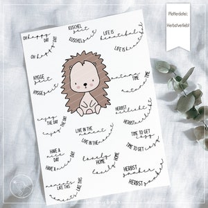 May include: A printable sheet with a cute hedgehog illustration and various autumn-themed phrases in English and German. The phrases include "Oh happy day", "Hygge seit", "Kuschel seit", "Life is beautiful", "Enjoy the day", "Live in the moment", "Have a nice day", "Moments like this", "Autumn time", "Herbst verliebt", "Herbst", "Time to get cozy", "Lovely home", "Herbst  zauber".