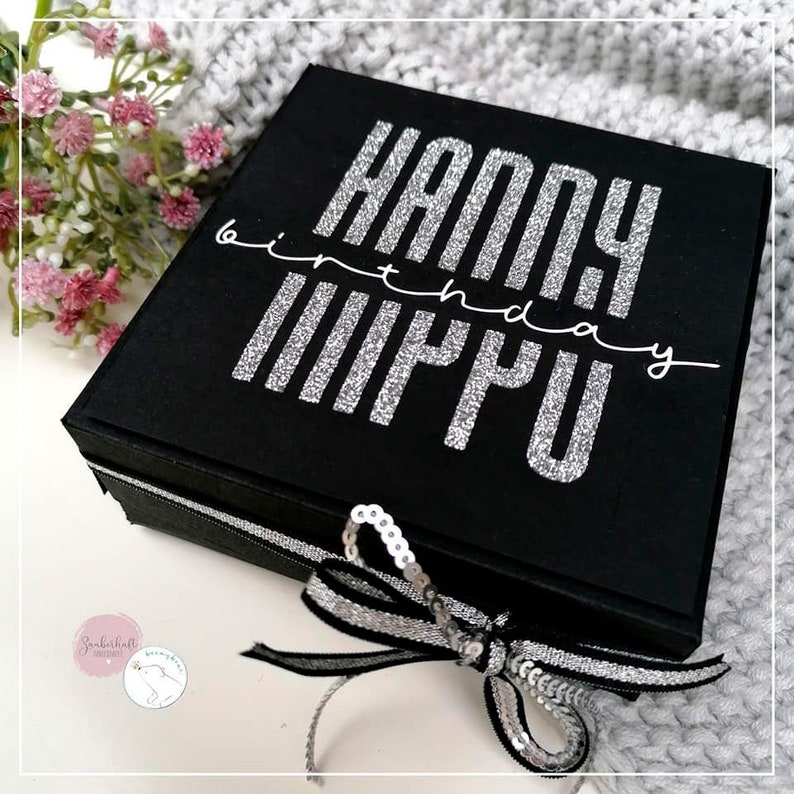 May include: Black gift box with a silver glitter "Happy Birthday" inscription on the lid. The box is tied with a black and silver ribbon and decorated with silver sequins.