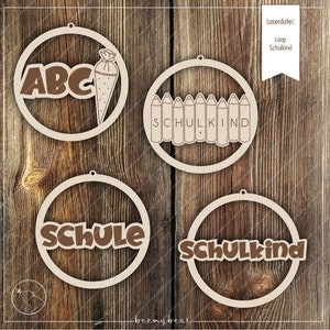 May include: Four wooden circle ornaments with cutouts. The ornaments feature the words "ABC", "Schulkind", "Schule", and "Schulkind".