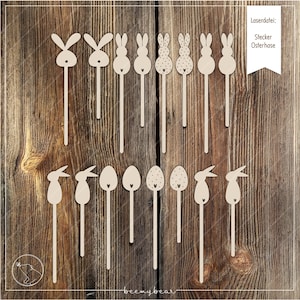 Może przedstawiać: Zestaw 14 laserowo wyciętych drewnianych kształtów zajączków i jajek wielkanocnych na patyczkach. Kształty zajączków mają prosty wzór z dwoma uszami i sercem na klatce piersiowej. Kształty jajek mają serce, a niektóre mają kropki. Tekst "LaserdDatei: Stecker Osterhase" znajduje się w prawym górnym rogu obrazu.